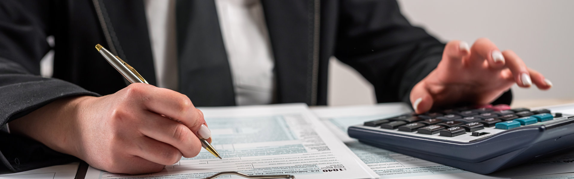 A lawyer holding a pen and typing on a calculator